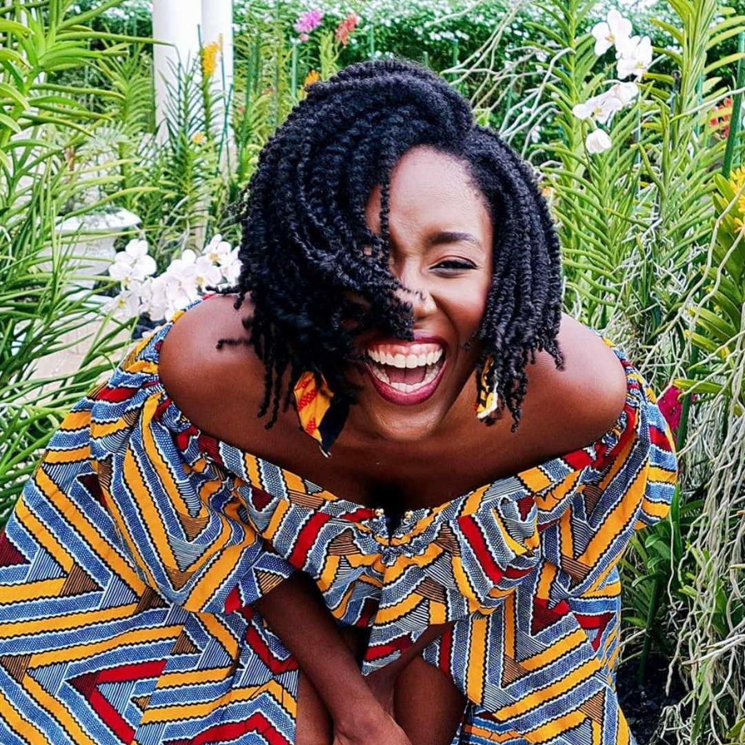 Chelsea Wallace laughing in front of green foliage and orchid blooms